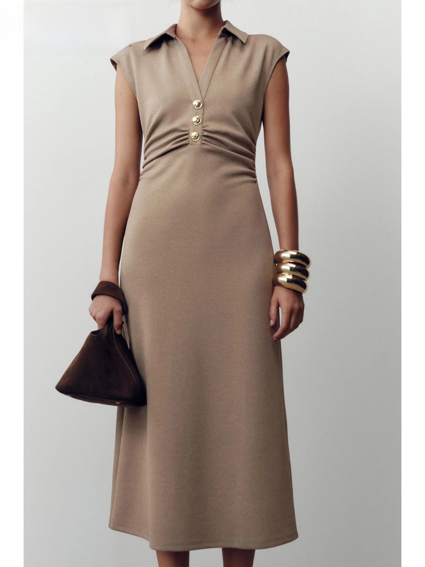 Woman wearing a beige dress with a plain background