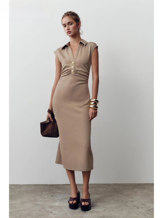 Woman wearing a beige dress with a plain background